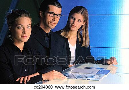 Three businesspeople looking at camera View Large Photo Image Stock Image - Three businesspeople looking at camera. Fotosearch
