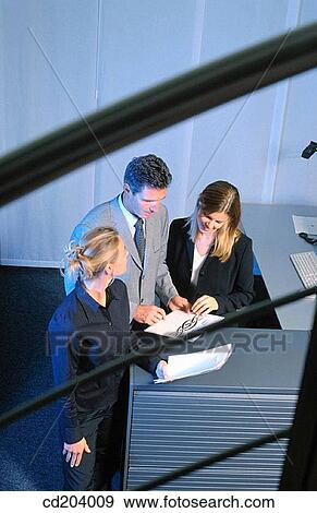 Three businesspeople looking on files View Large Photo Image Stock Photo - Three businesspeople looking on files. Fotosearch