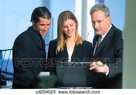 Three businesspeople looking on laptop View Large Photo Image Stock Image - Three businesspeople looking on laptop. Fotosearch