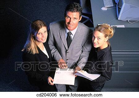 Three businesspeople with files looking at camera View Large Photo Image Stock Photograph - Three businesspeople with files looking at camera. Fotosearch