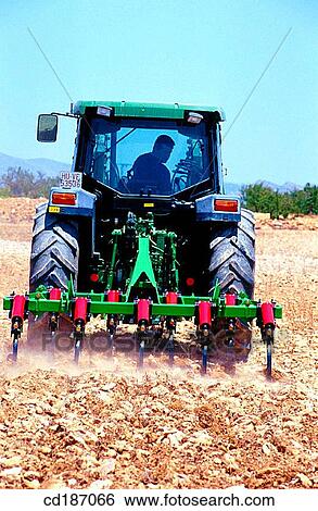 Tractor dragging a plough View Large Photo Image Stock Photograph - Tractor dragging a plough. Fotosearch