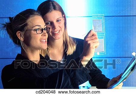 Two businesswomen looking at two samples View Large Photo Image Stock Photo - Two businesswomen looking at two samples. Fotosearch