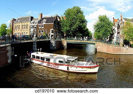 Stock Image - Water-taxi on canal. Amsterdam. Holland. Fotosearch
