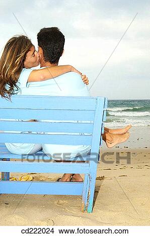 Picture - back view, beach, bench, blond, blue. Fotosearch
