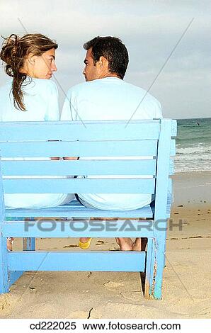 Stock Photography - back view, beach, bench, blond, blue. Fotosearch