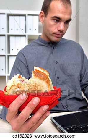 Businessman eating while working View Large Photo Image Stock Image - Businessman eating while working. Fotosearch