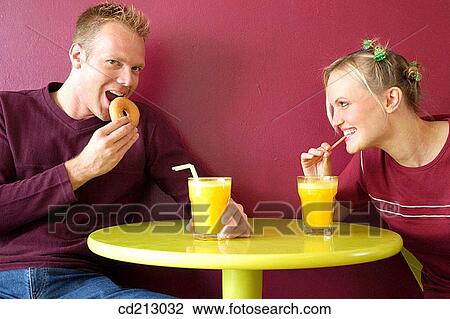 Stock Image - Couple drinking orange juice. Fotosearch