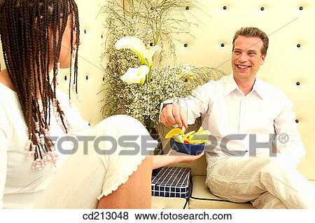 Stock Photo - Couple eating fruits in bar. Fotosearch