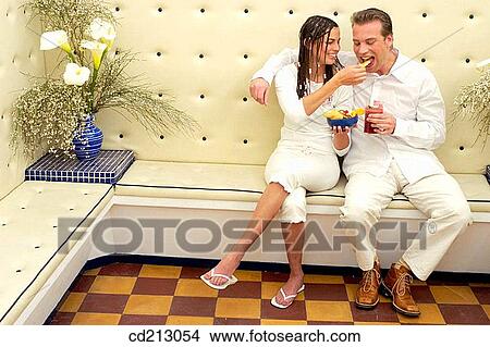 Picture - Couple in bar sharing fruits. Fotosearch