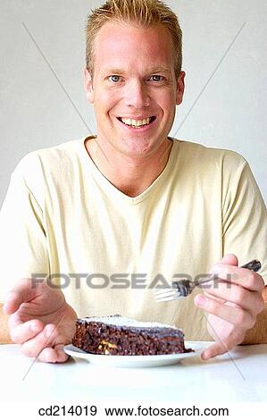 Man eating chocolate cake View Large Photo Image Stock Photo - Man eating chocolate cake. Fotosearch