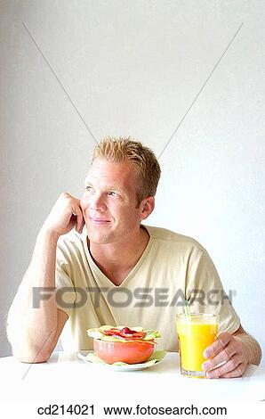 Stock Image - Man eating fruit salad. Fotosearch
