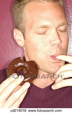 Man savouring donut View Large Photo Image Stock Photo - Man savouring donut. Fotosearch