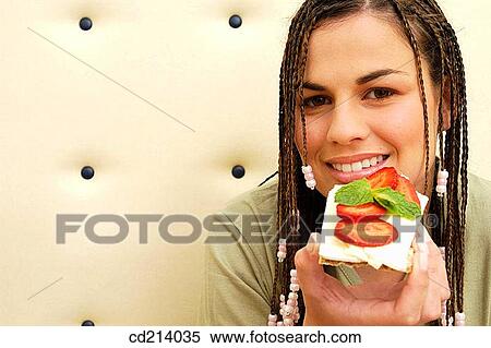 Stock Photography - Woman eating cheese toast. Fotosearch