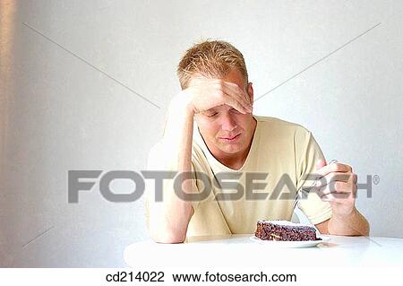 Worried man eating chocolate cake View Large Photo Image Stock Image - Worried man eating chocolate cake. Fotosearch