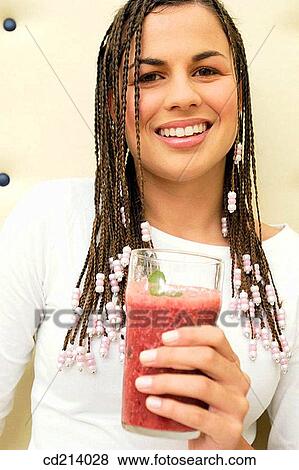 Young woman holding glass juice View Large Photo Image Stock Photo - Young woman holding glass juice. Fotosearch