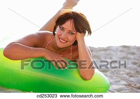 Stock Image - air-bed, brunette, beach, air mattress. Fotosearch