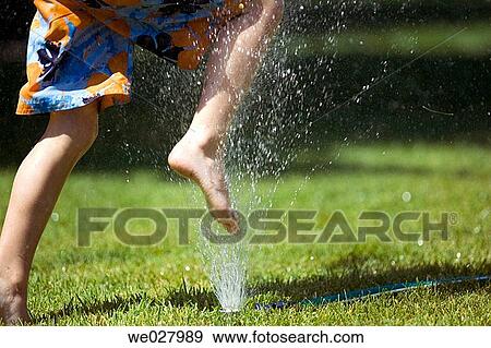 Boy, 5, jumping over lawn sprinkler. Boise, Idaho. USA View Large Photo Image Stock Photo - Boy, 5, jumping over lawn sprinkler. Boise, Idaho. USA. Fotosearch