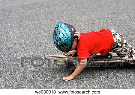 Stock Photo - Boy lying on skateboard. Fotosearch