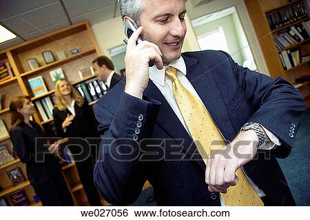 Stock Photograph - business, businessman, businesspeople, calling, cell phone, clock. Fotosearch