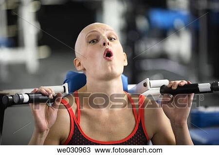 Stock Image - Caucasian woman with cancer/alopecia areata working out. Fotosearch