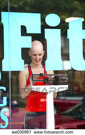Caucasian woman with cancer/alopecia areata weighing in on gym scale View Large Photo Image Stock Photo - Caucasian woman with cancer/alopecia areata weighing in on gym scale. Fotosearch