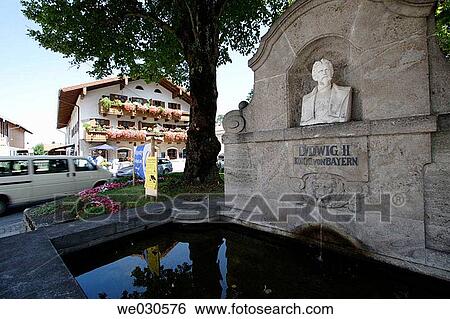 Stock Photograph - Fountain with bust of King Ludwig II of Bavaria in Grassau, Chiemgau, Upper Bavaria, Bavaria, Germany. Fotosearch