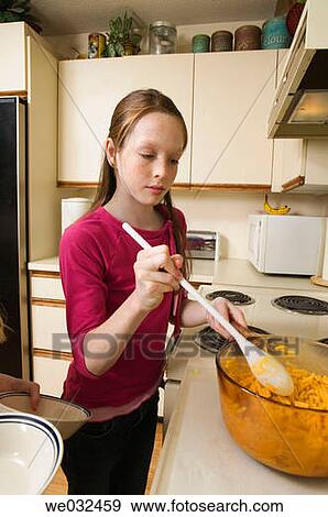 Stock Photo - 11 year old Caucasian girl making a meal. Fotosearch