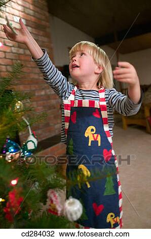 3 year old girl decorating Christmas tree View Large Photo Image Stock Image - 3 year old girl decorating Christmas tree. Fotosearch