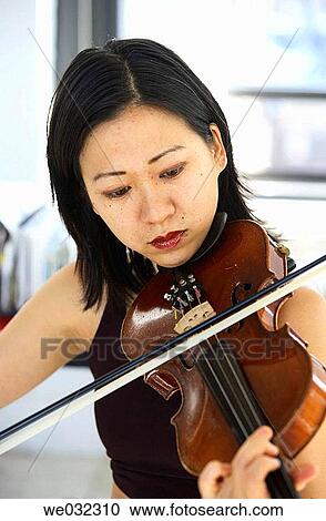 Stock Image - Asian/Chinese woman playing violin. Fotosearch