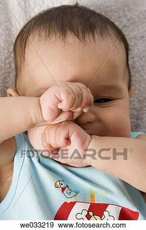 Stock Photo - Baby rubbing his eyes.. Fotosearch