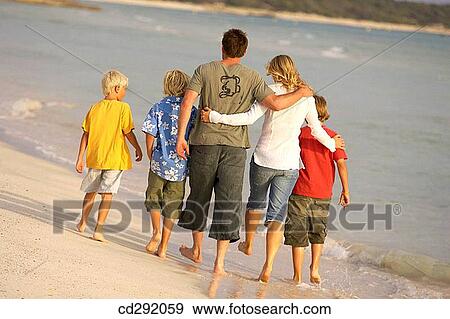 Stock Photo - back view, barefoot, beach, boy, brother. Fotosearch