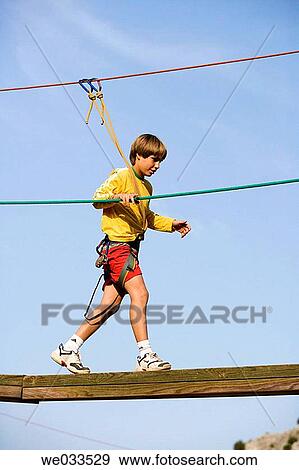 Boy walking on wooden bar in camp View Large Photo Image Stock Photo - Boy walking on wooden bar in camp. Fotosearch