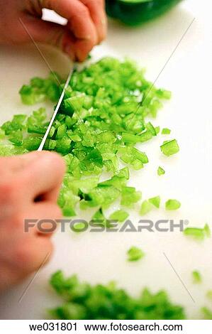 Stock Image - Chef/Cook chopping green peppers. Fotosearch
