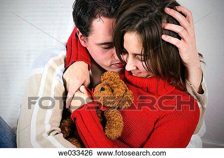 Couple cuddling with a soft toy animal View Large Photo Image Stock Photograph - Couple cuddling with a soft toy animal. Fotosearch