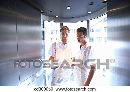 Doctors in lift View Large Photo Image Stock Image - Doctors in lift. Fotosearch