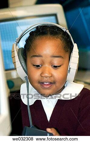 Stock Photo - Girl with computer headphones at school. Fotosearch