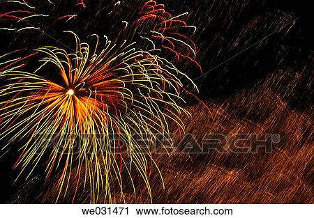 Stock Image - Green, gold and red fireworks in night sky. Fotosearch