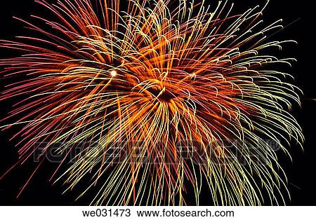 Stock Image - Green, gold and red fireworks in night sky. Fotosearch