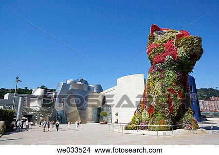 Picture - Guggenheim Museum by Frank O. Gehry with? Puppy?, sculpture by Jeff Koons, at fore. Bilbao. Biscay, Euskadi, Spain. Fotosearch