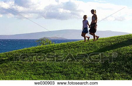 Mother and daughter walking near ocean View Large Photo Image Stock Image - Mother and daughter walking near ocean. Fotosearch