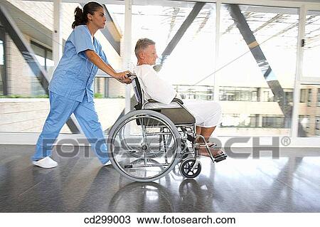 Nurse pushing patient in wheelchair View Large Photo Image Stock Image - Nurse pushing patient in wheelchair. Fotosearch