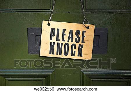 Stock Photograph - Please Knock sign hanging on front door. Fotosearch