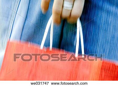 Shopper holding bag View Large Photo Image Stock Photo - Shopper holding bag. Fotosearch