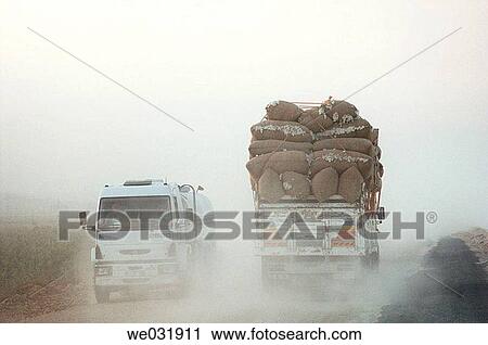 Trucks loaded with bales of cotton on a dusty road near Harran, Turkey. View Large Photo Image Stock Image - Trucks loaded with bales of cotton on a dusty road near Harran, Turkey.. Fotosearch