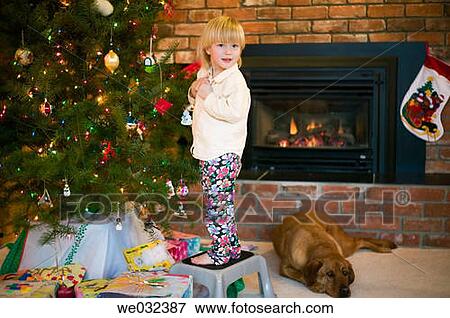 Young girl decorating Christmas tree View Large Photo Image Stock Photo - Young girl decorating Christmas tree. Fotosearch