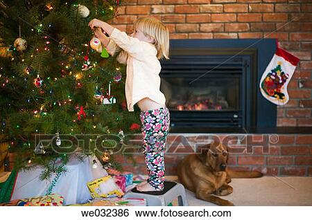 Young girl decorating Christmas tree View Large Photo Image Stock Photograph - Young girl decorating Christmas tree. Fotosearch