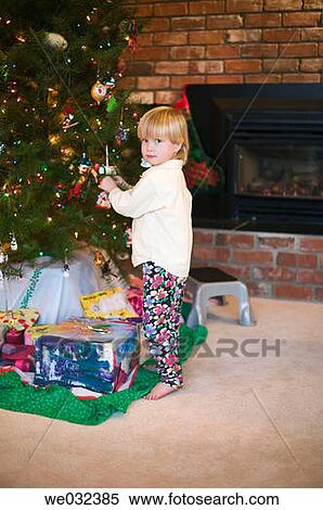 Young girl decorating Christmas tree View Large Photo Image Stock Photography - Young girl decorating Christmas tree. Fotosearch