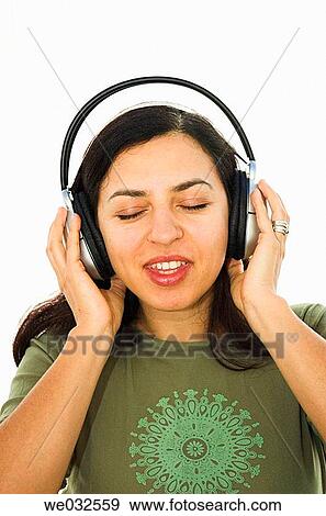 Stock Photo - Young woman enjoying music through headphones. Fotosearch