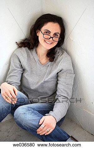 20? s-30's caucasian woman sitting in corner peering over glasses View Large Photo Image Stock Image - 20? s-30's caucasian woman sitting in corner peering over glasses. Fotosearch