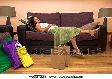 Stock Photo - A young woman rests after a hard day shopping.. Fotosearch